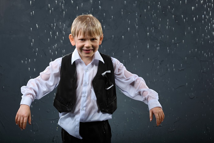 雨にぬれるスーツ姿の少年